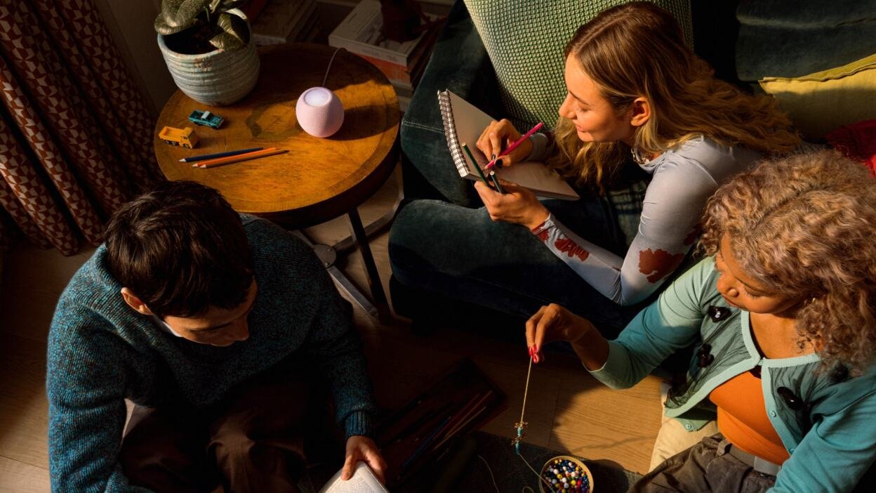 young people sitting around apple homepod mini 2 smart speaker in living room
